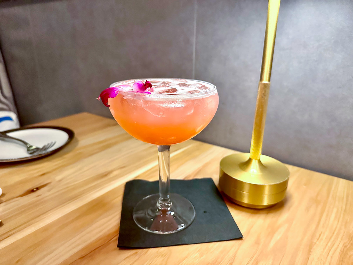 pink drink in a cocktail glass on a wooden table